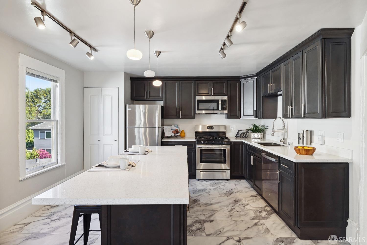 1817 Woolsey Street Berkeley, CA 94703 - Photo 15 of 35 a kitchen with kitchen island granite countertop a sink stainless steel appliances and cabinets
