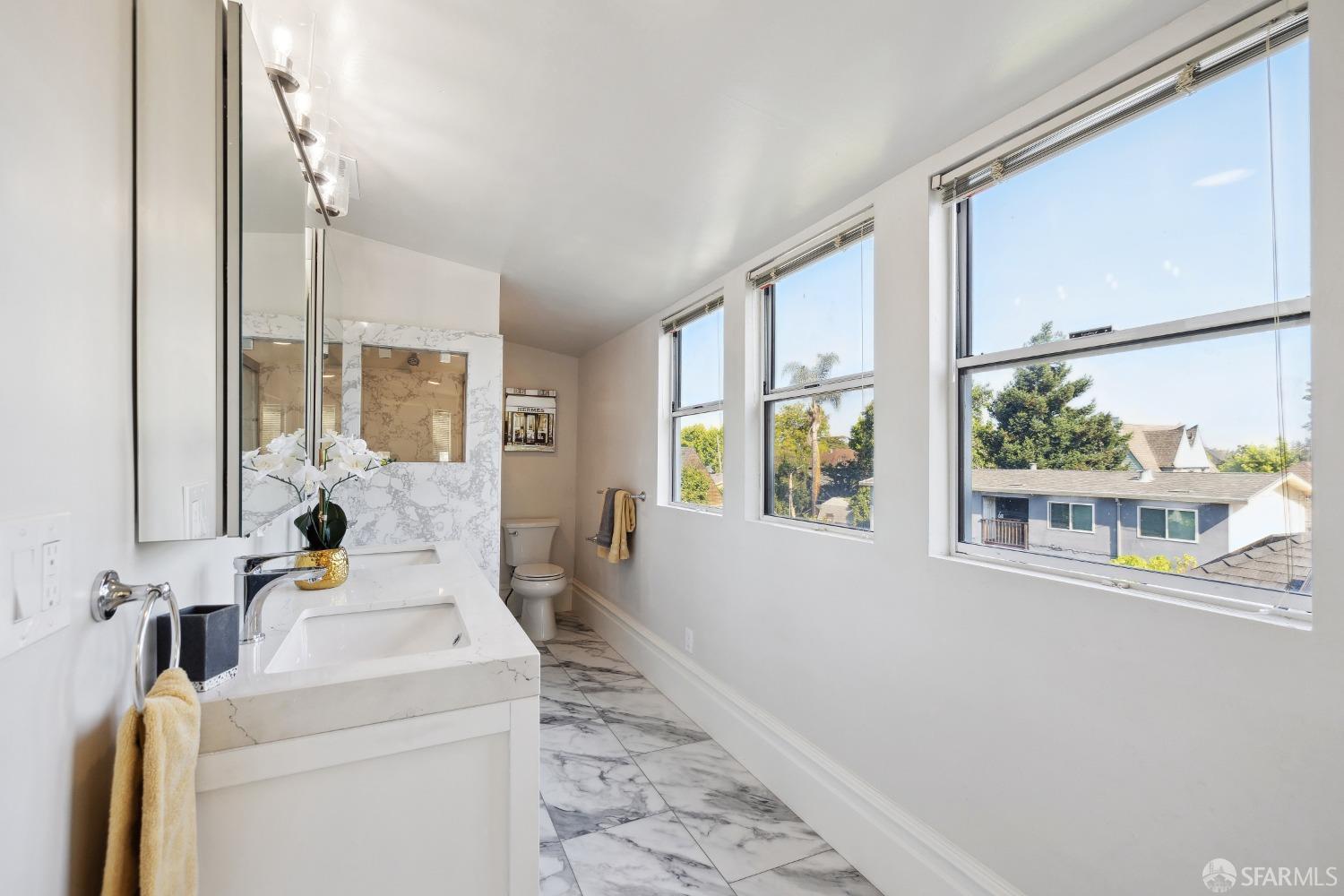 1817 Woolsey Street Berkeley, CA 94703 - Photo 23 of 35 a bathroom with a sink and a large mirror next to a window