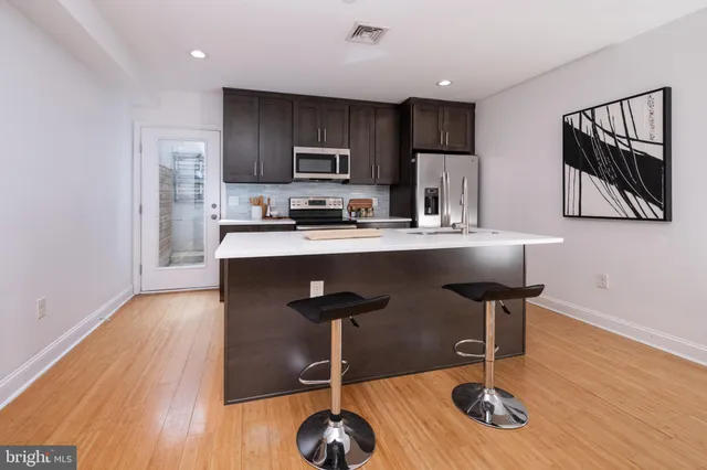 a kitchen with wooden floors and wooden cabinets