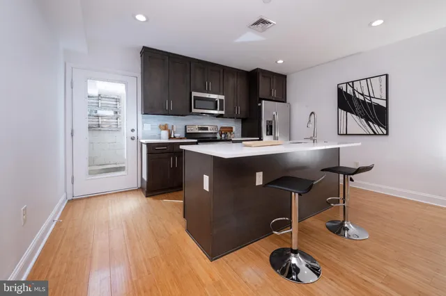 a kitchen with stainless steel appliances granite countertop a sink a stove and a refrigerator