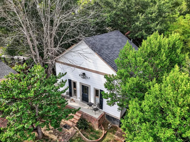 a front view of a house with a yard garden and trees