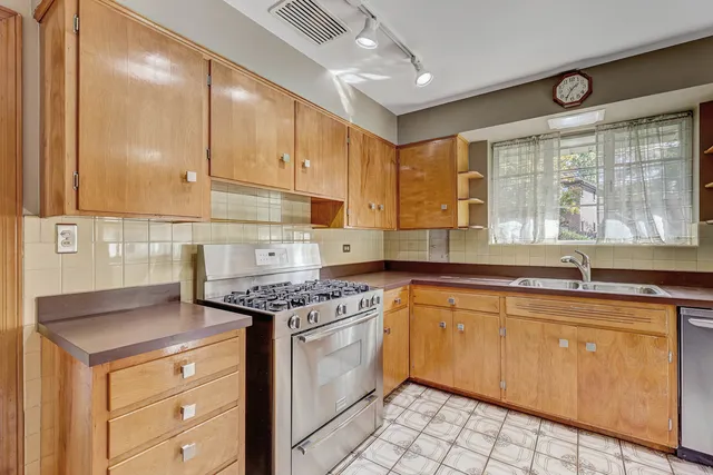 a kitchen with granite countertop cabinets stainless steel appliances a sink and a window