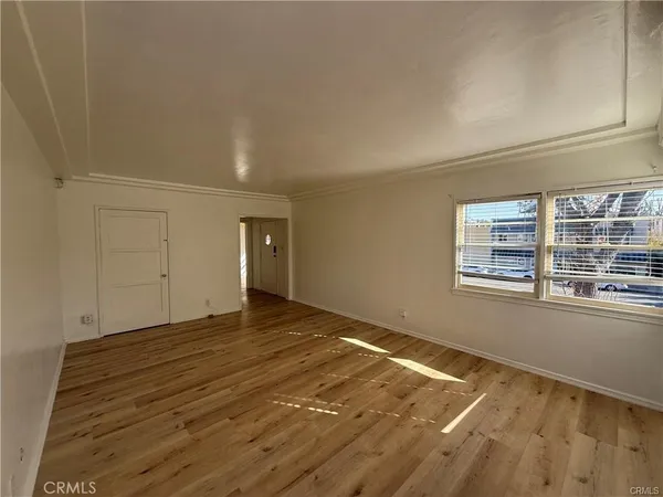 a view of a room with wooden floor and window