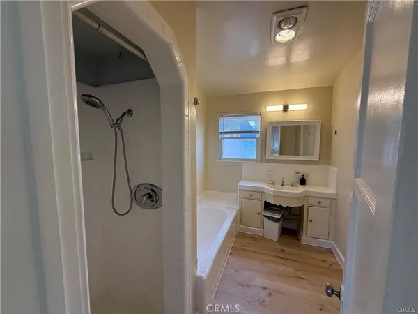 a view of a room with wooden floor staircase and a bathroom