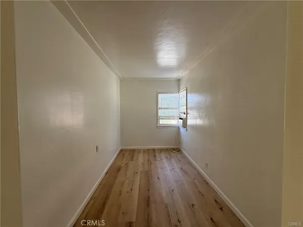 a view of a room with wooden floor and window