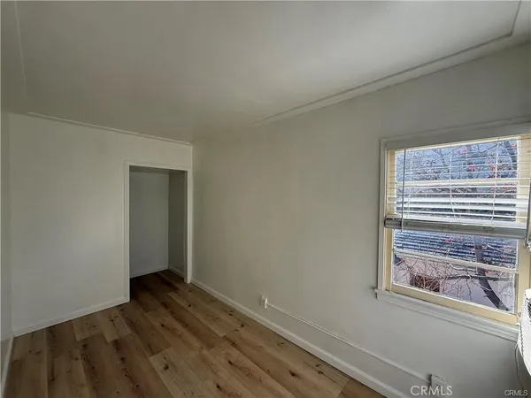 a view of small space with wooden floor and a bathroom