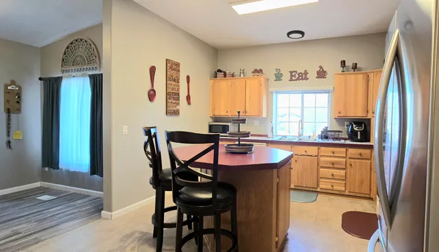 a kitchen with stainless steel appliances granite countertop a stove a refrigerator and a refrigerator with wooden floor