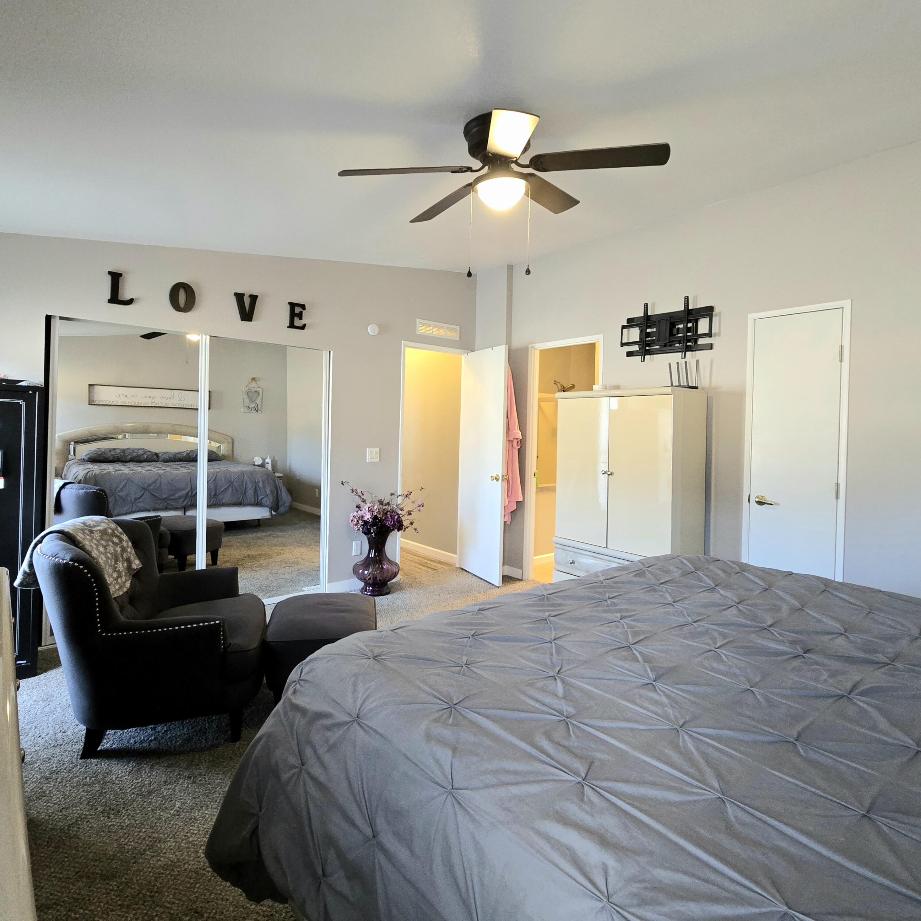 16617 Cottonwood Creek Road Hornbrook, CA 96044 - Photo 21 of 43 a spacious bedroom with a bed a couch and a ceiling fan