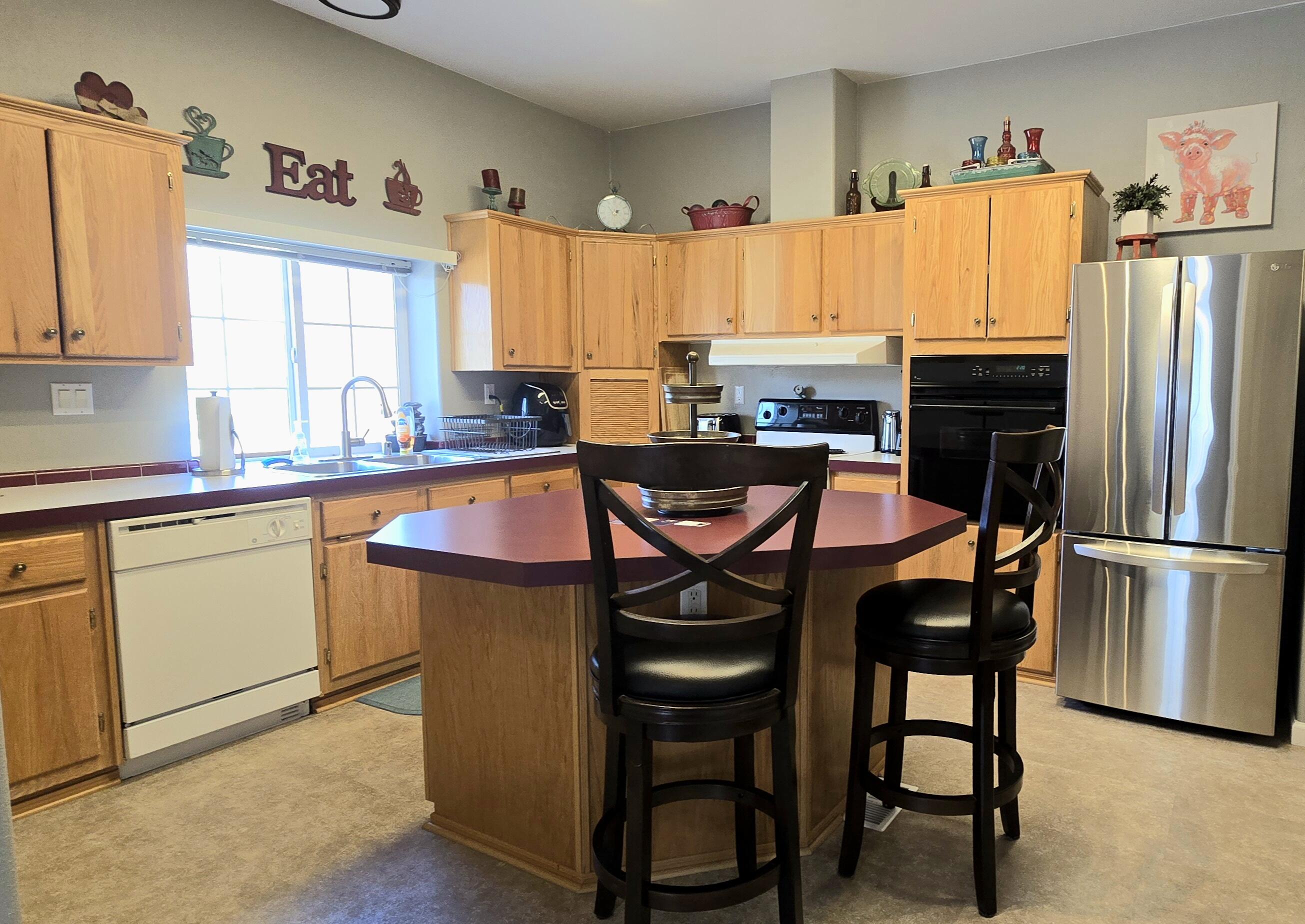 16617 Cottonwood Creek Road Hornbrook, CA 96044 - Photo 9 of 43 a kitchen with stainless steel appliances granite countertop a table chairs and a refrigerator