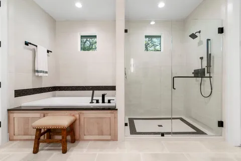 a spacious bathroom with a double vanity sink toilet mirror and shower