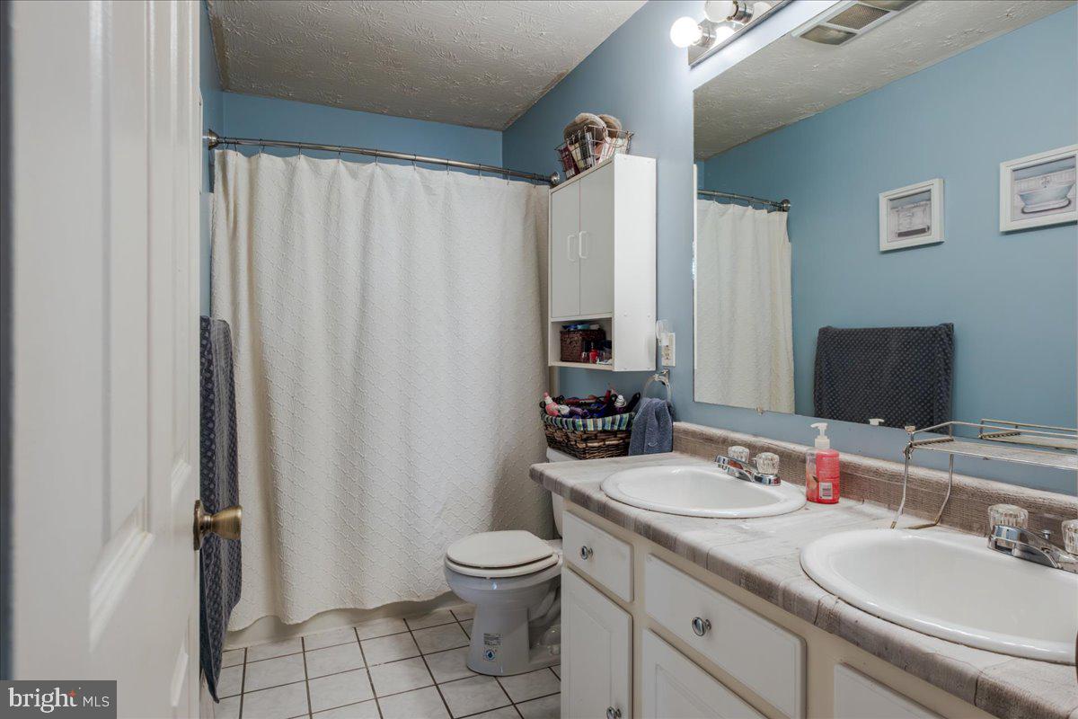 11419 Oak Grove Road Bristol, VA 24202 - Photo 16 of 36 a bathroom with a granite countertop sink toilet and shower