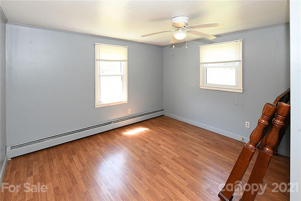 479 Joe Hampton Road Lansing, NC 28643 - Photo 16 of 44 a view of empty room with wooden floor and fan