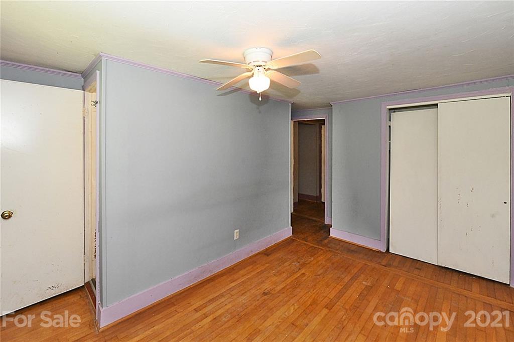 479 Joe Hampton Road Lansing, NC 28643 - Photo 22 of 44 a view of an empty room with wooden floor and a ceiling fan