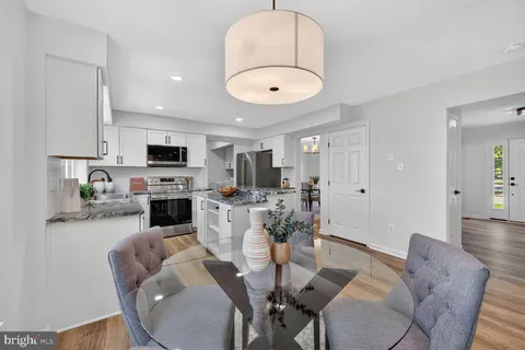 a living room with furniture a fireplace and a dining table with wooden floor
