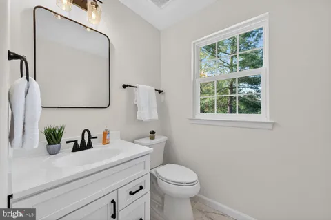 a bathroom with a sink a toilet and a mirror