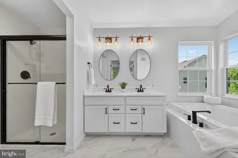 a en suite bathroom with a granite countertop double vanity sink and a large mirror