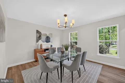 a view of a dining room with furniture a potted plant and wooden floor