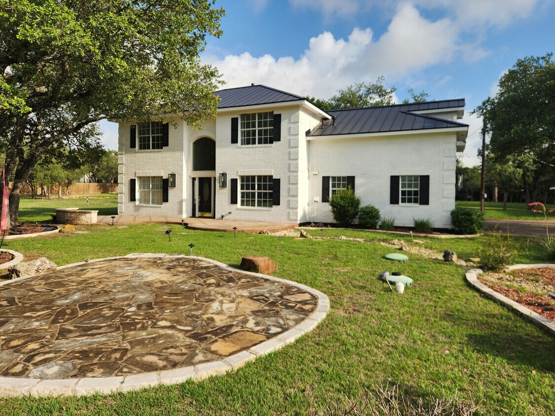 102 County Road 180 Leander, TX 78641 - Photo 2 of 25 A classic brick exterior with dark shutters and a metal roof creates impressive curb appeal.