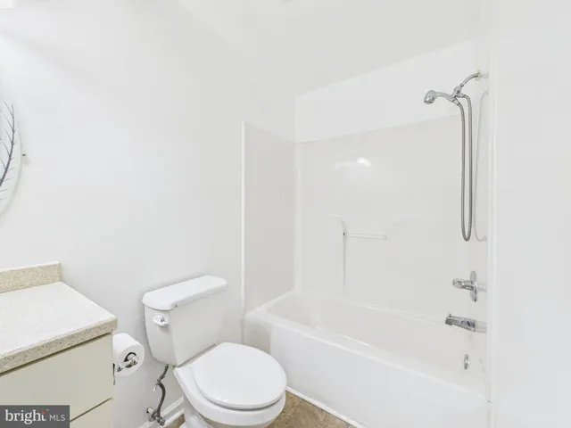a white toilet sitting next to a bath tub