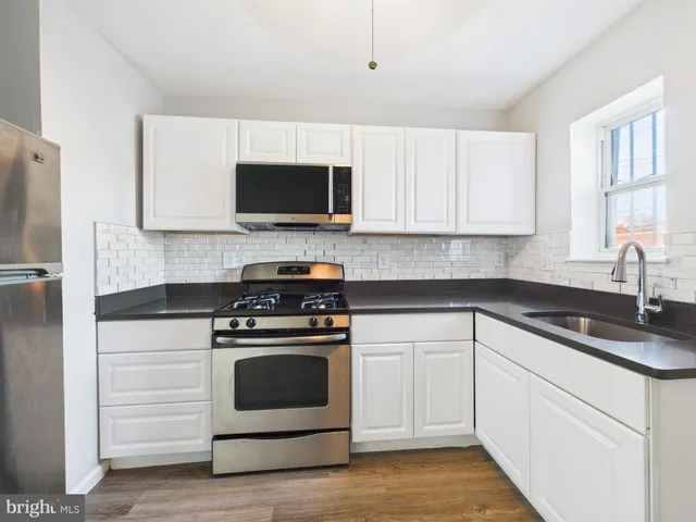 a kitchen with white cabinets and stainless steel appliances