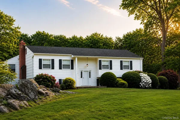 a view of a house with a big yard and large trees