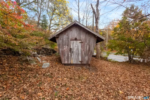 a view of a small house with a tree and wooden fence