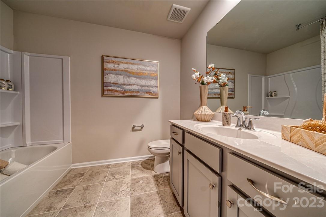 6017 Chelsea Oaks Ridge, Unit 2086 Tega Cay, SC 29708 - Photo 10 of 12 a bathroom with a sink a toilet and tub