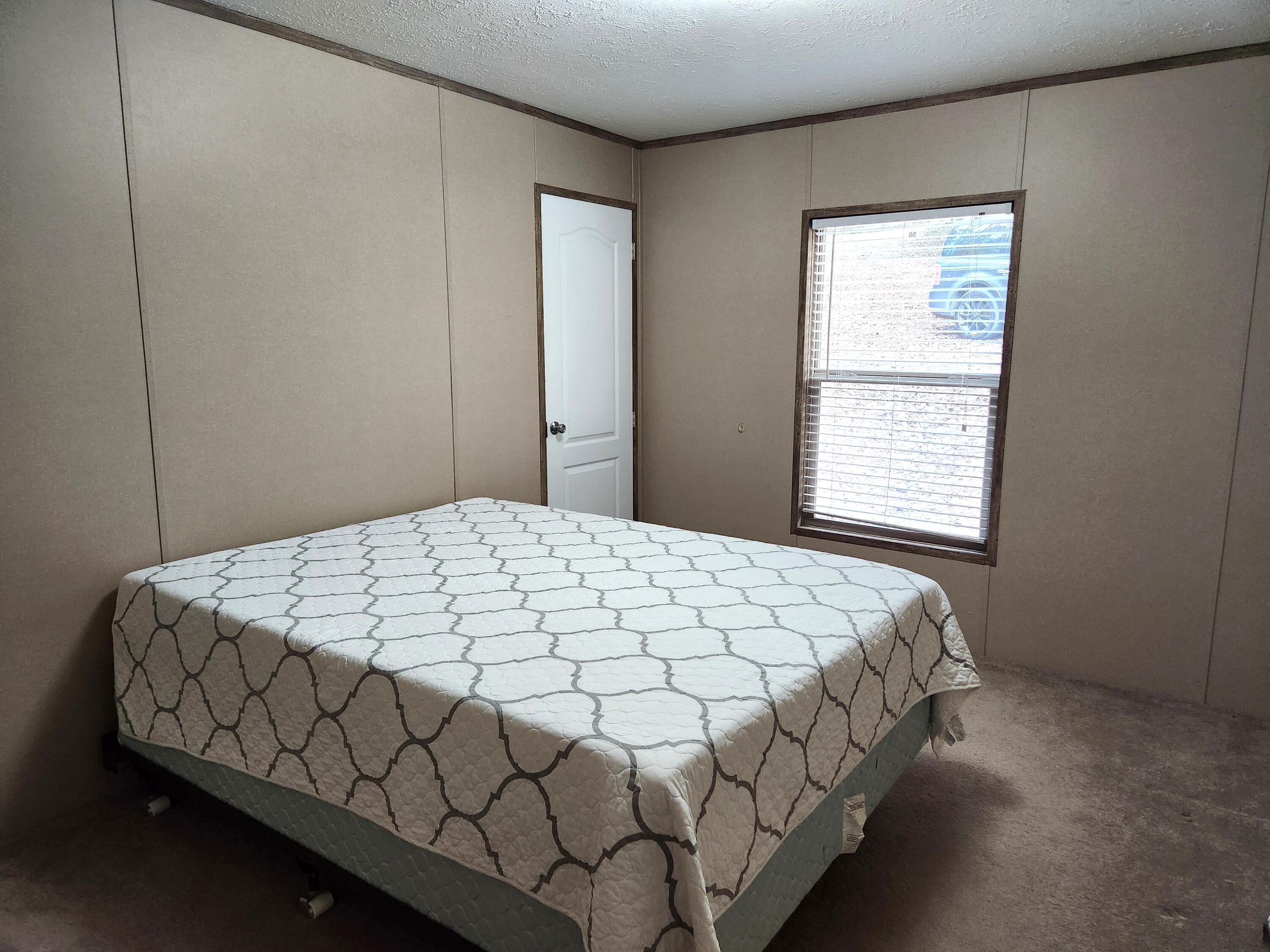 300 Whisperway Road Moneta, VA 24121 - Photo 19 of 24 a bed sitting in a bedroom next to a window