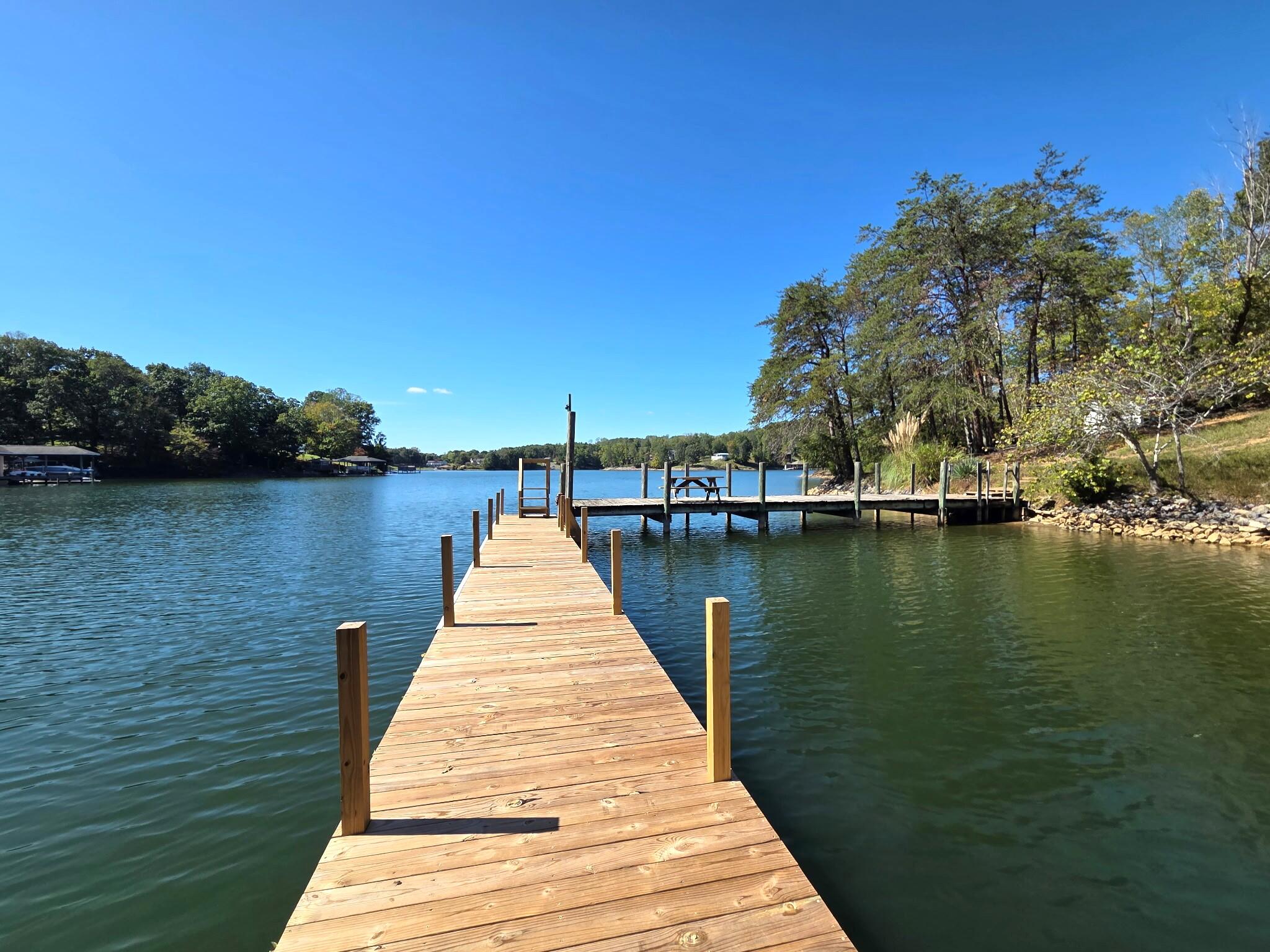 300 Whisperway Road Moneta, VA 24121 - Photo 3 of 24 a wooden pier with boats in a lake