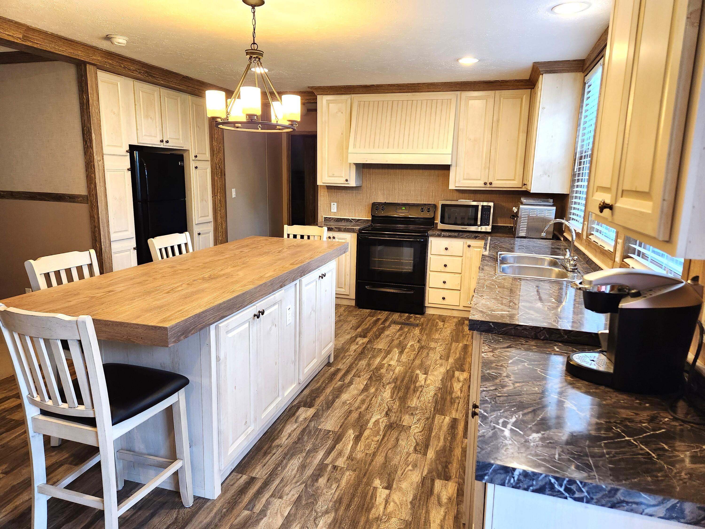 300 Whisperway Road Moneta, VA 24121 - Photo 5 of 24 a large kitchen with kitchen island granite countertop a stove refrigerator and microwave