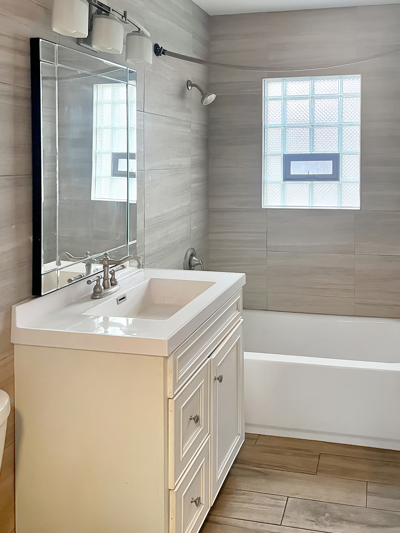 28 West 35th Place Steger, IL 60475 - Photo 15 of 20 a bathroom with a sink a bathtub and a window