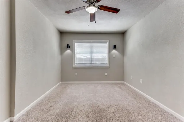 an empty room with closet and a chandelier fan