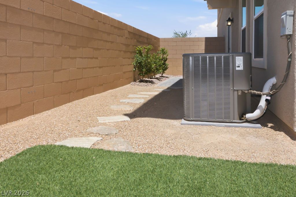 913 Cadence View Way Henderson, NV 89011 - Photo 40 of 46 A neatly maintained backyard features a pathway of stepping stones and a compact lawn.