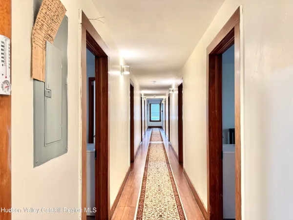 a view of a hallway with wooden floor and stairs