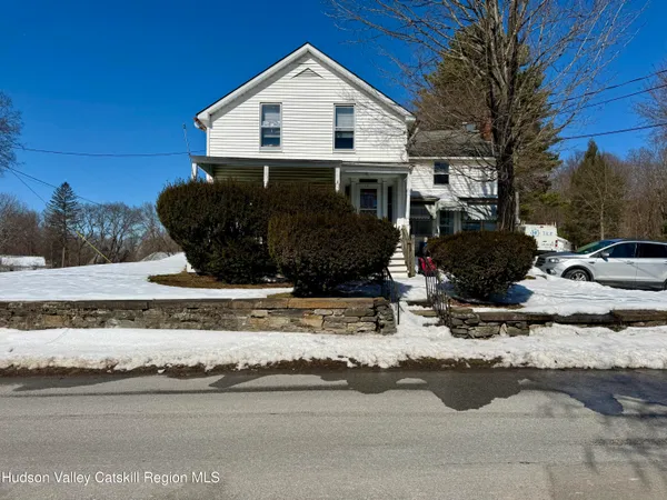 a view of a house with a yard covered in snow