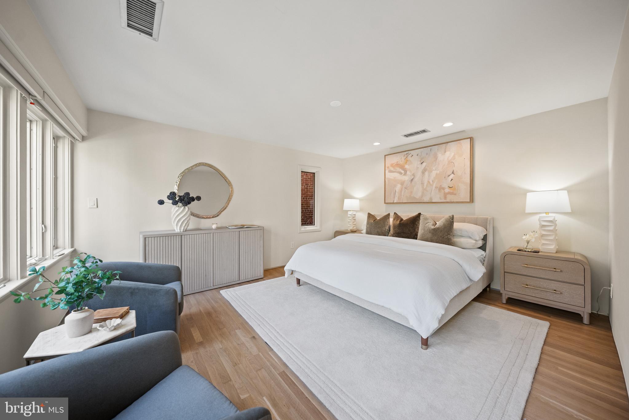2319 Bancroft Place Northwest Washington, DC 20008 - Photo 14 of 37 a spacious bedroom with a bed a couch and potted plant on the dresser