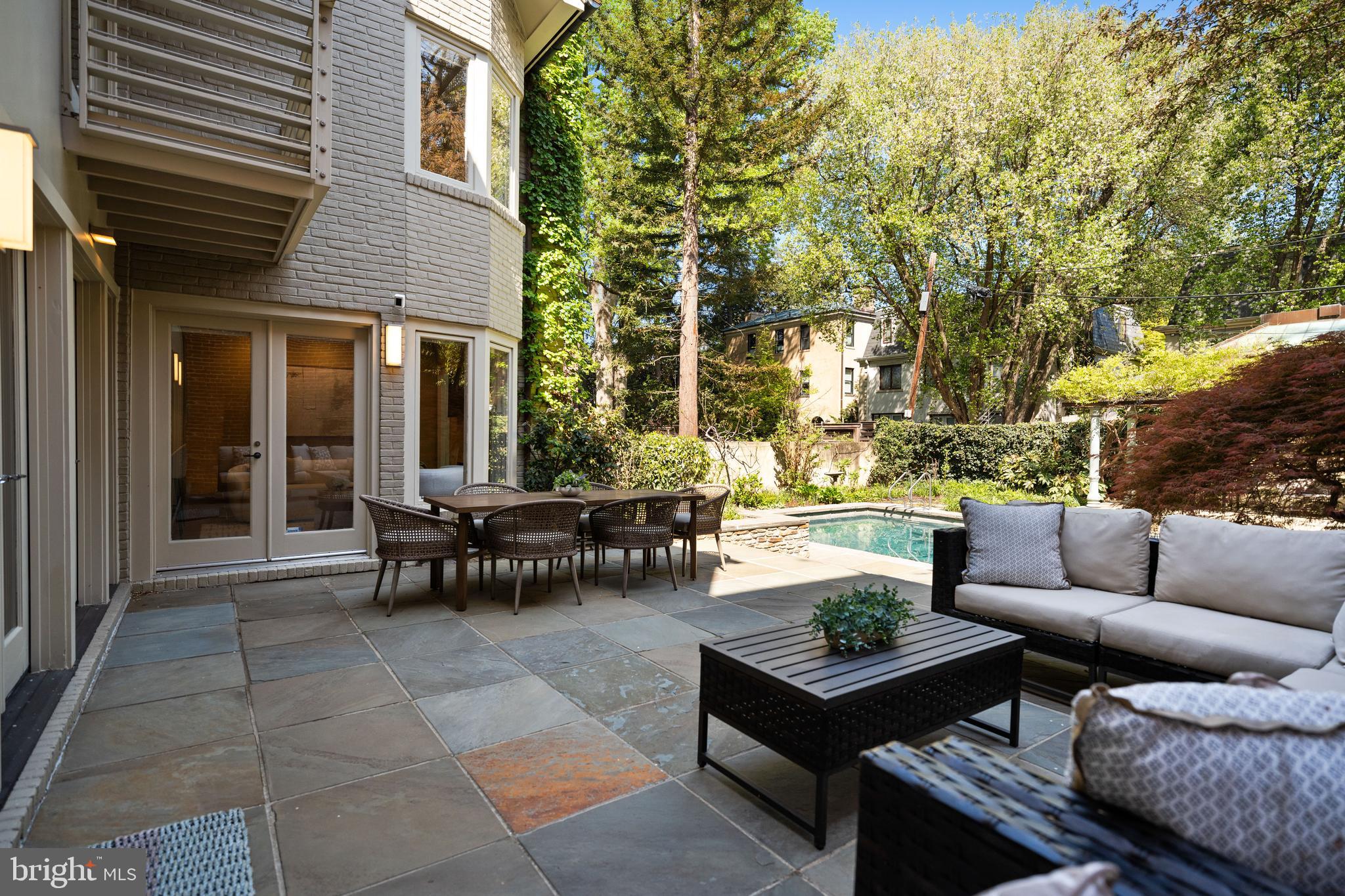 2319 Bancroft Place Northwest Washington, DC 20008 - Photo 34 of 37 a view of a patio with couches and a table and chairs with floor to ceiling window and large tree