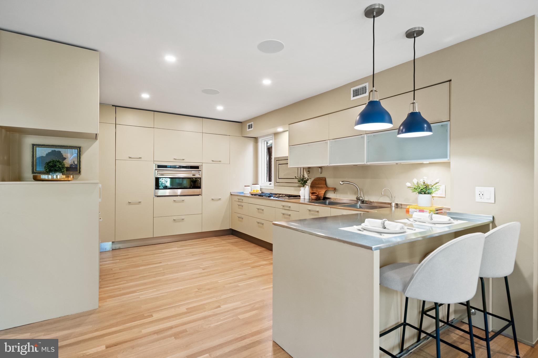 2319 Bancroft Place Northwest Washington, DC 20008 - Photo 6 of 37 a kitchen with stainless steel appliances granite countertop a sink a stove a refrigerator and island with wooden floor