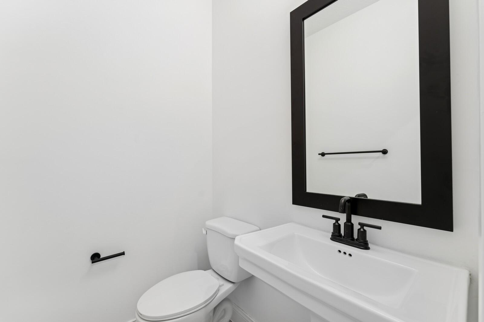 188 Southeast Birch Terrace, Unit 313 Stuart, FL 34997 - Photo 3 of 30 a bathroom with a toilet sink and mirror
