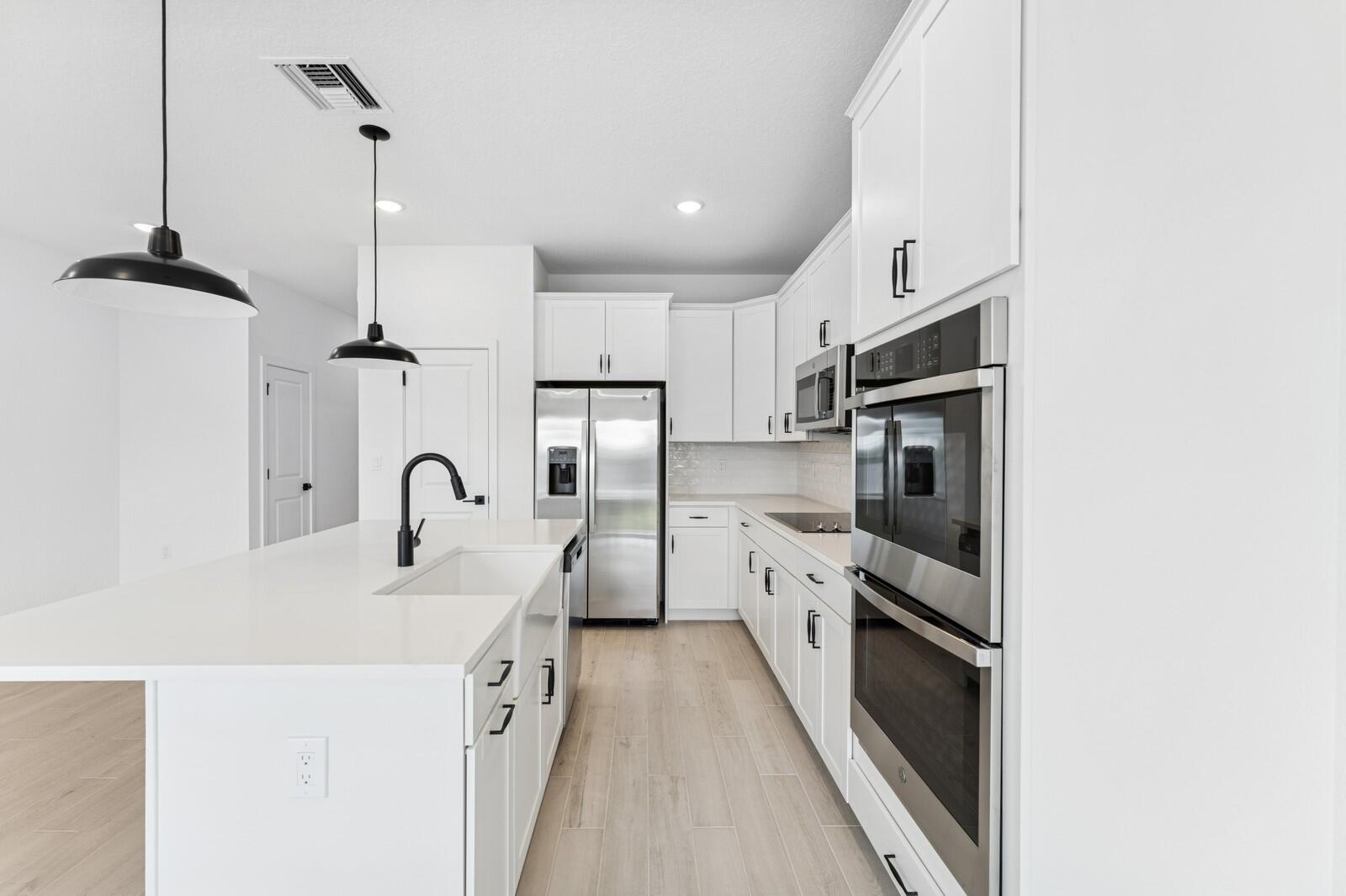 188 Southeast Birch Terrace, Unit 313 Stuart, FL 34997 - Photo 7 of 30 a kitchen with stainless steel appliances a sink a stove a refrigerator and cabinets