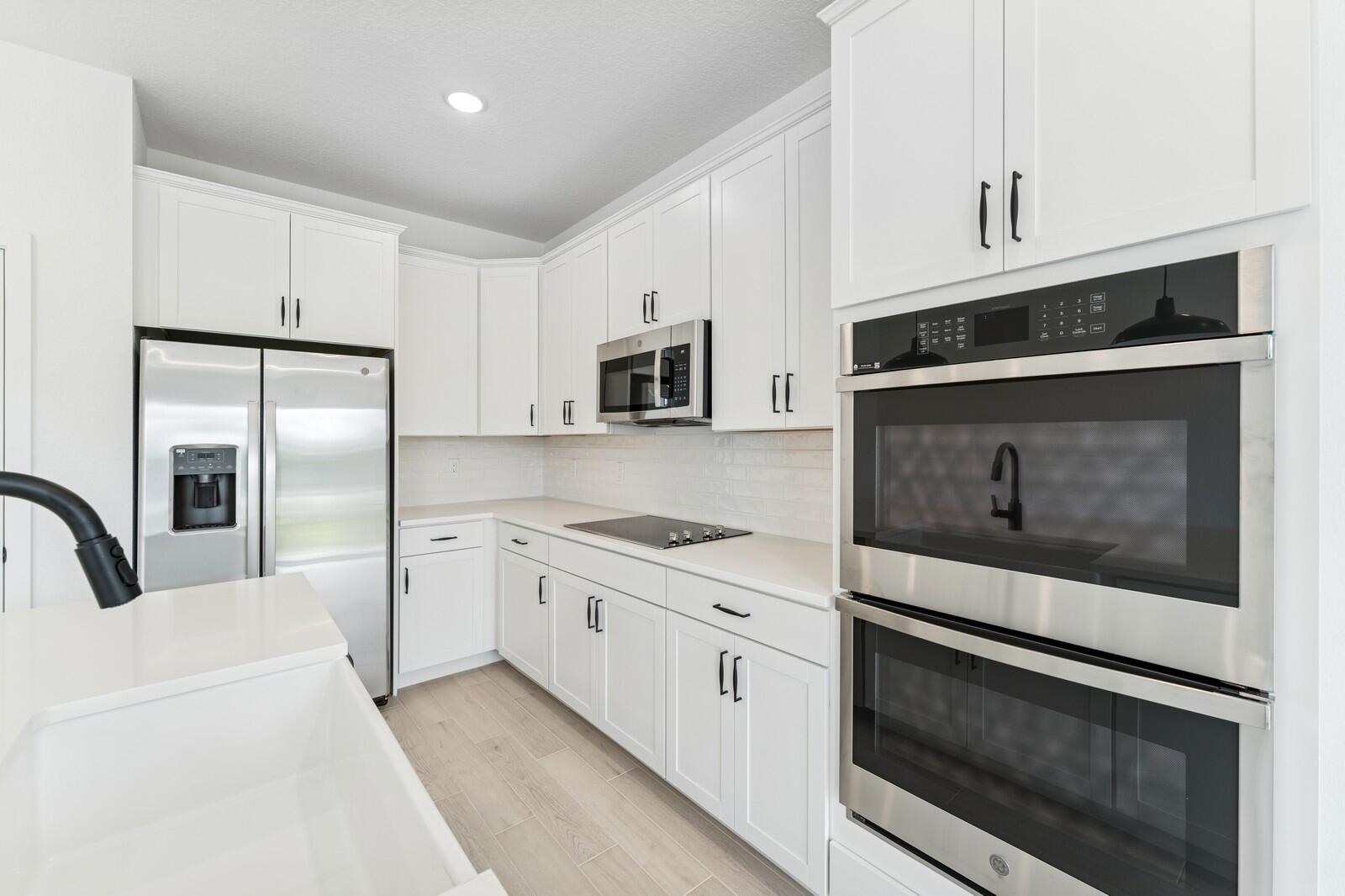 188 Southeast Birch Terrace, Unit 313 Stuart, FL 34997 - Photo 8 of 30 a kitchen with stainless steel appliances granite countertop a stove microwave and refrigerator