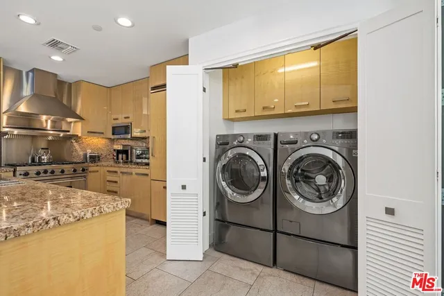a view of a kitchen with kitchen island stainless steel appliances wooden floor and a window