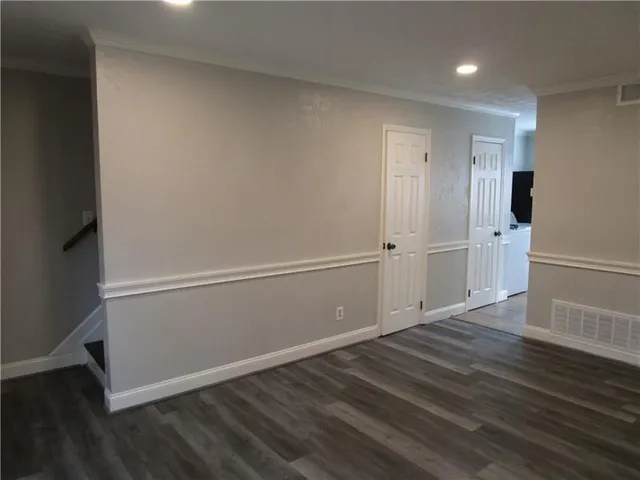 an empty room with wooden floor and white walls
