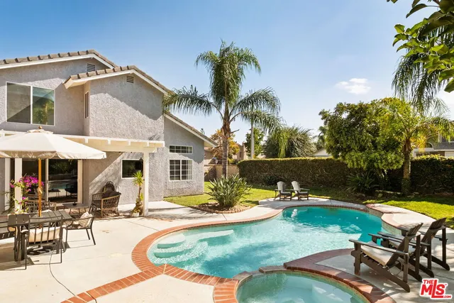 a swimming pool with outdoor seating and yard