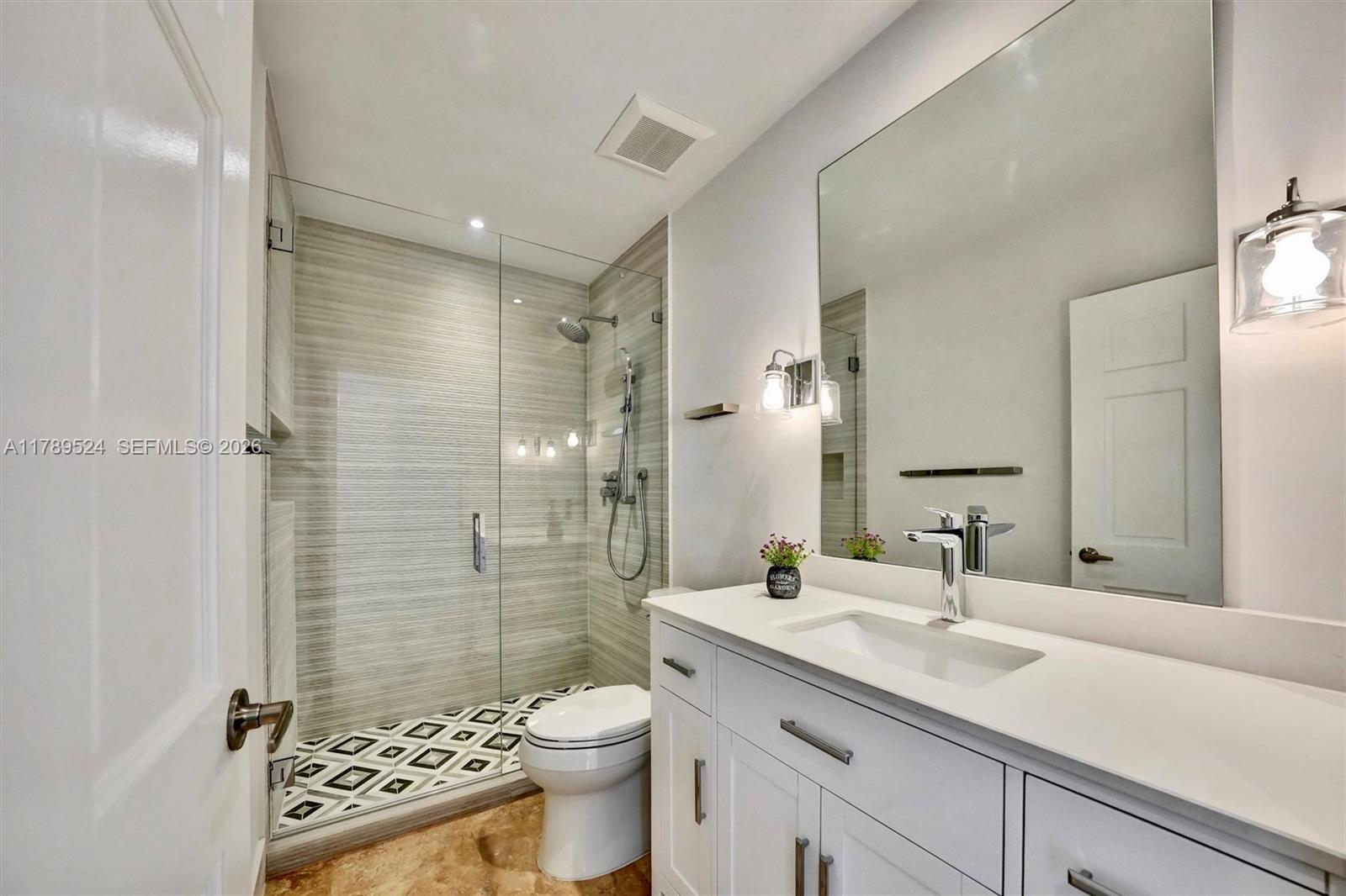 255 Ridgewood Road Key Biscayne, FL 33149 - Photo 35 of 61 a bathroom with a sink toilet a shower and a mirror