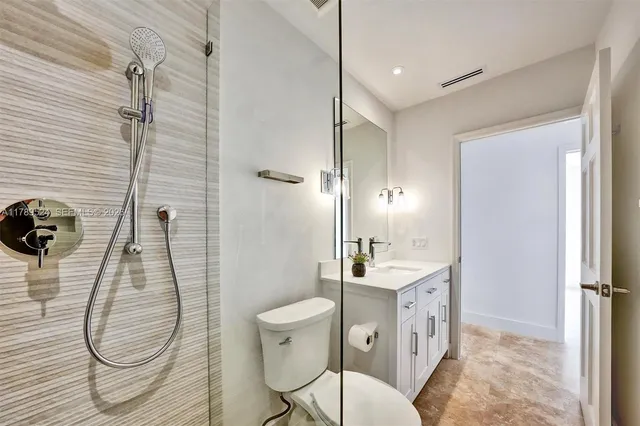 a bathroom with a sink a toilet and a large mirror