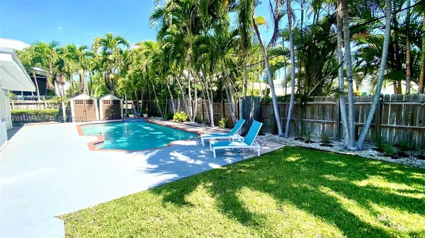 a view of a house with backyard sitting area and garden