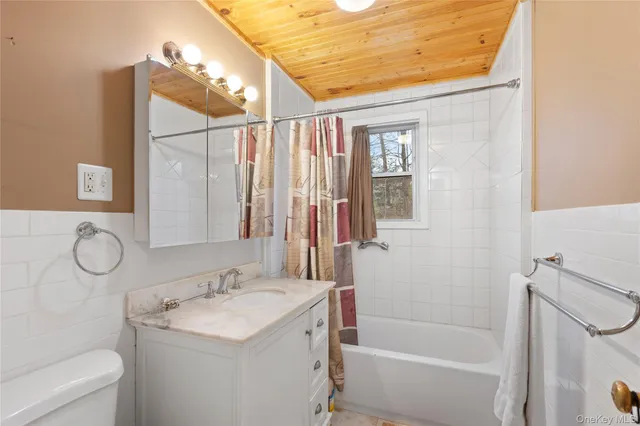a bathroom with a granite countertop sink a toilet and shower