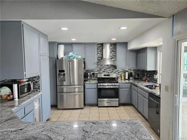 a kitchen with granite countertop a refrigerator and a stove