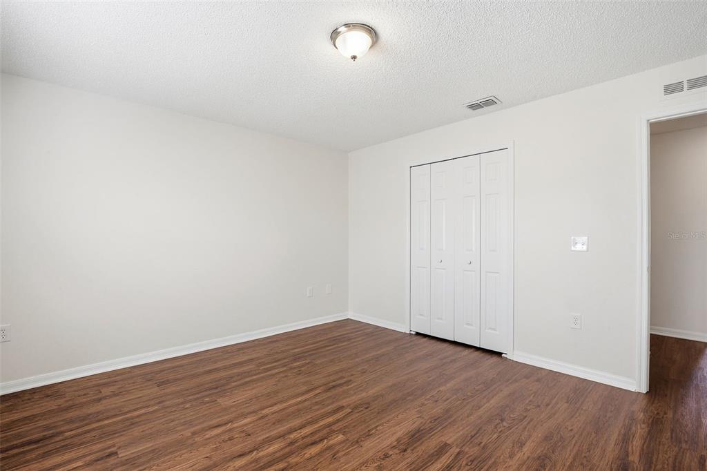 11331 Ivy Flower Loop Riverview, FL 33578 - Photo 27 of 36 a view of an empty room with wooden floor